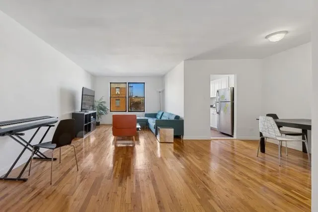 a view of a room with wooden floor lounge chair and windows