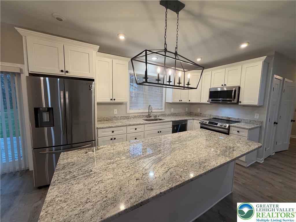 7120 Suter Road Coopersburg, PA 18036 - Photo 4 of 17 a kitchen with stainless steel appliances granite countertop a sink refrigerator and microwave