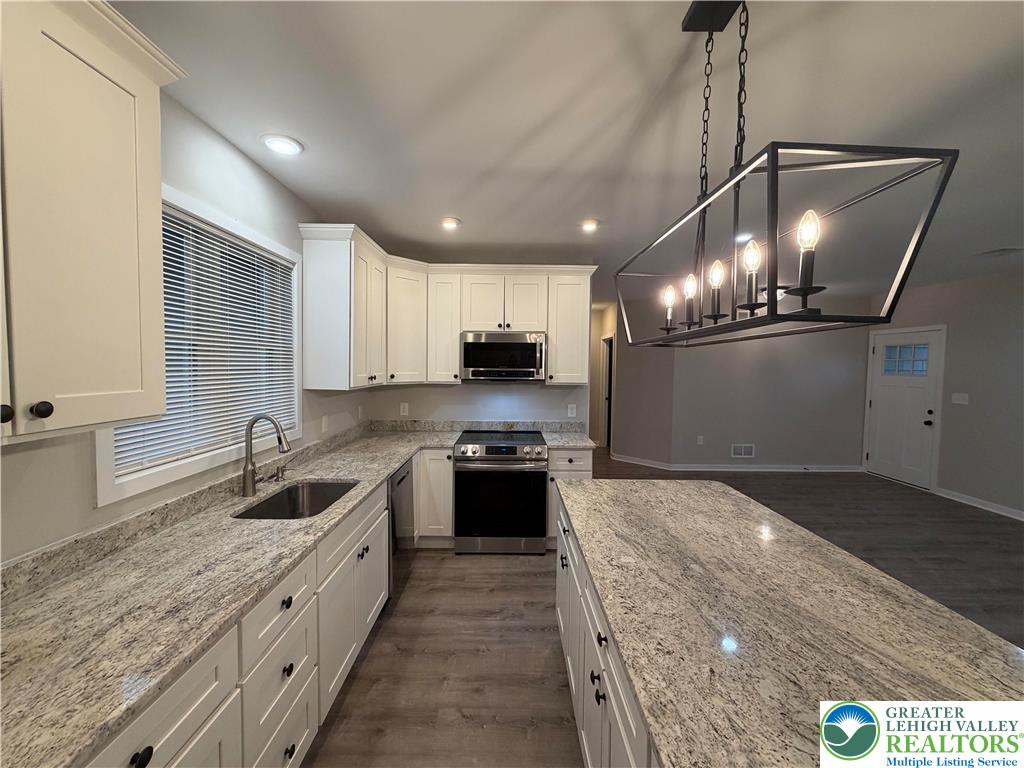 7120 Suter Road Coopersburg, PA 18036 - Photo 5 of 17 a kitchen with granite countertop a stove and cabinets