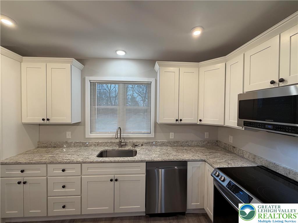 7120 Suter Road Coopersburg, PA 18036 - Photo 6 of 17 a kitchen with stainless steel appliances granite countertop a sink a stove and a microwave