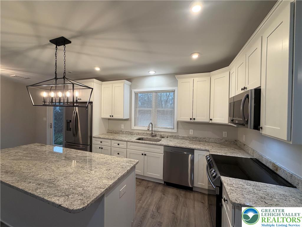 7120 Suter Road Coopersburg, PA 18036 - Photo 7 of 17 a kitchen with stainless steel appliances granite countertop a sink a stove and a refrigerator