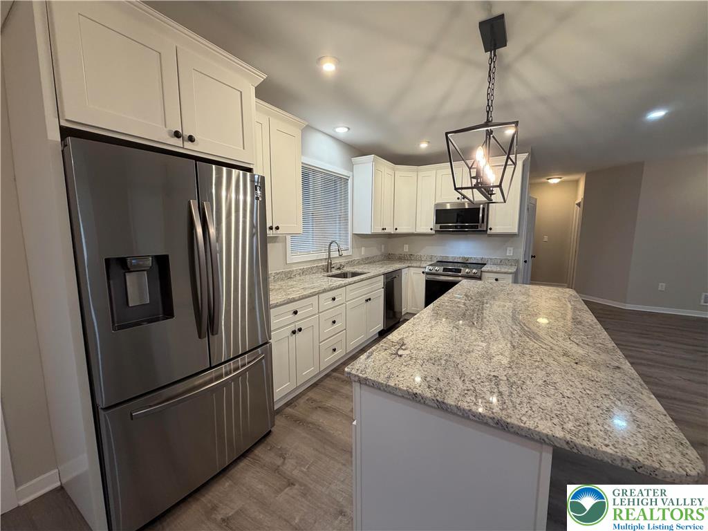 7120 Suter Road Coopersburg, PA 18036 - Photo 8 of 17 a kitchen with stainless steel appliances granite countertop a refrigerator a sink and a stove