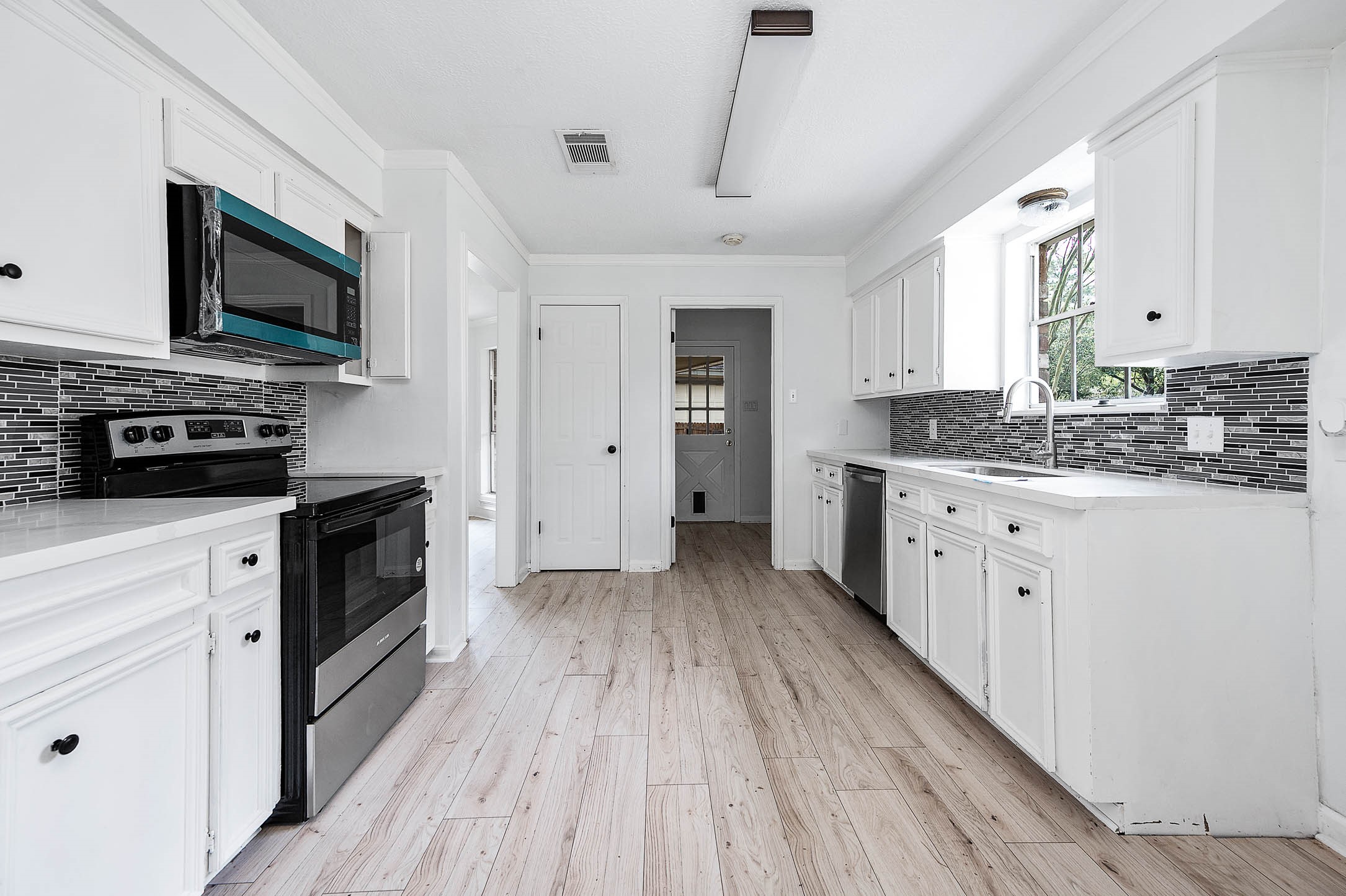 17627 Terrawren Lane Spring, TX 77379 - Photo 11 of 30 a kitchen with stainless steel appliances a stove top oven a sink dishwasher and a refrigerator with wooden floor