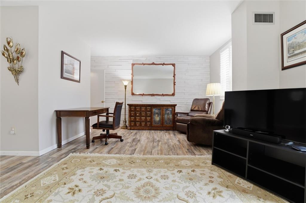 5715 Beacon Street, Unit 107 Pittsburgh, PA 15217 - Photo 16 of 50 a living room with furniture a piano and a flat screen tv