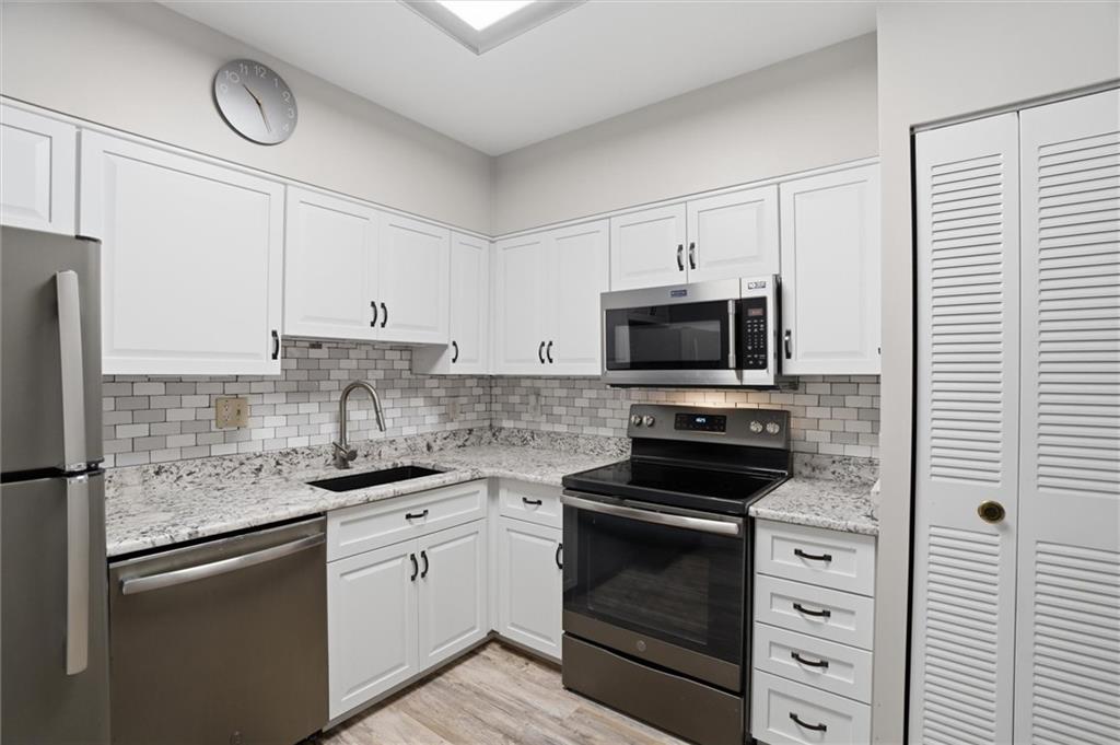 5715 Beacon Street, Unit 107 Pittsburgh, PA 15217 - Photo 21 of 50 a kitchen with white cabinets stainless steel appliances and sink