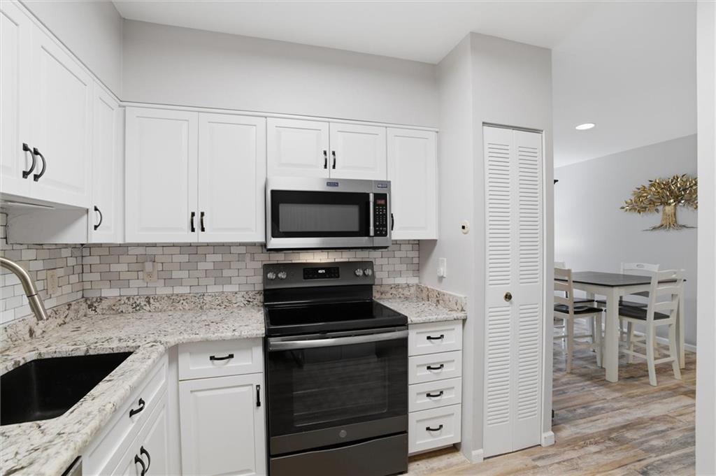 5715 Beacon Street, Unit 107 Pittsburgh, PA 15217 - Photo 22 of 50 a kitchen with white cabinets and stainless steel appliances