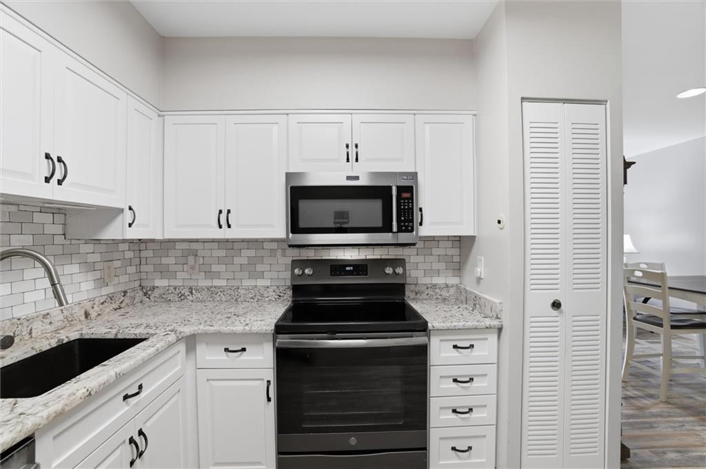 5715 Beacon Street, Unit 107 Pittsburgh, PA 15217 - Photo 23 of 50 a kitchen with granite countertop a stove and a sink