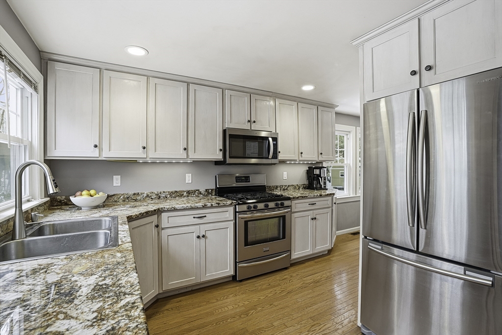 300 West Main Street Hopkinton, MA 01748 - Photo 10 of 28 a kitchen with granite countertop white cabinets and stainless steel appliances