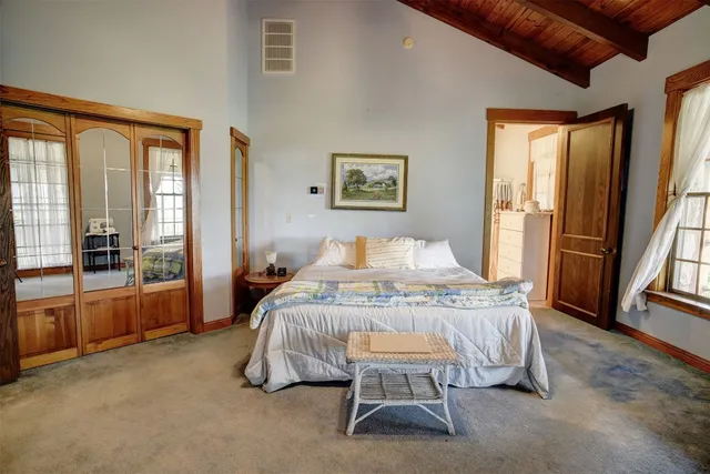 a bedroom with a large bed and a chandelier