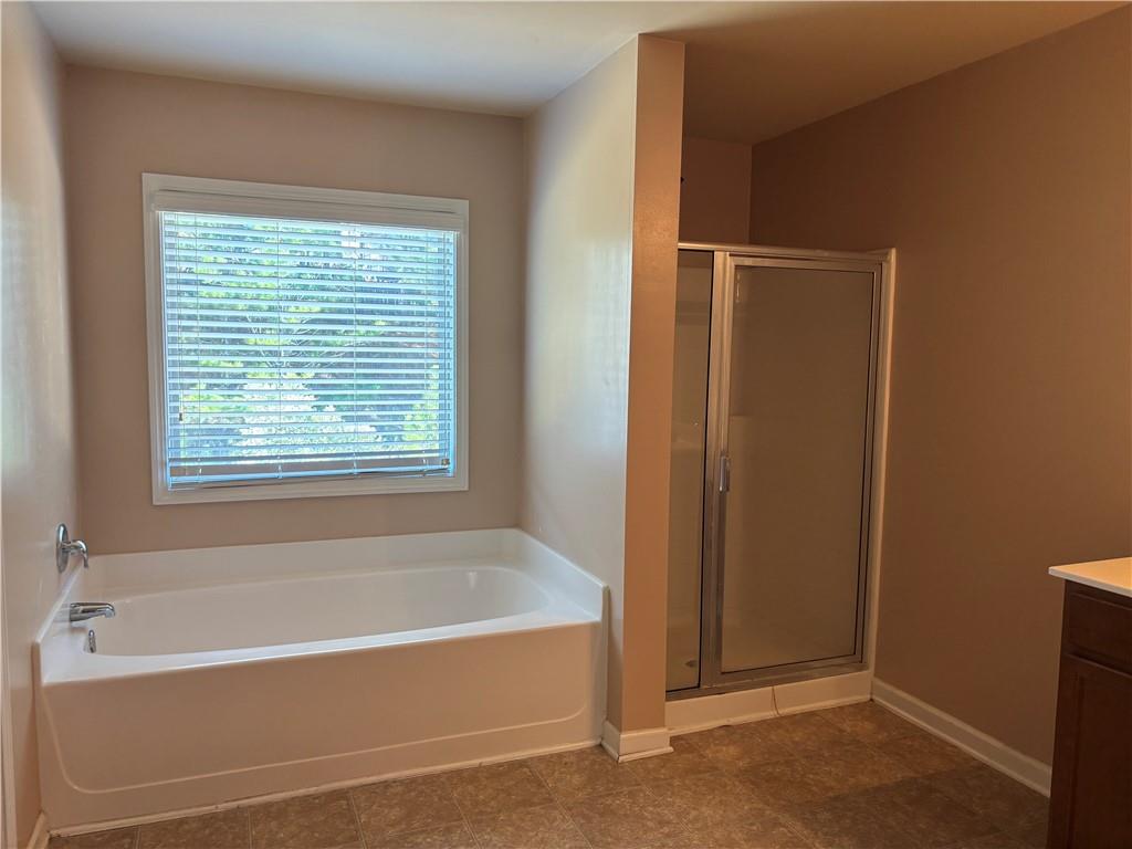 7562 Watson Circle Locust Grove, GA 30248 - Photo 26 of 66 a bathroom with a bathtub and a shower