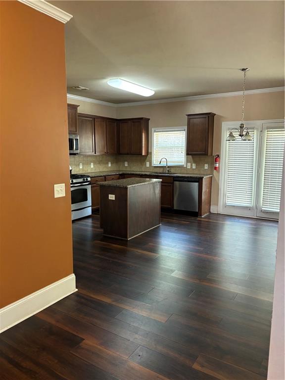 7562 Watson Circle Locust Grove, GA 30248 - Photo 41 of 66 a large kitchen with stainless steel appliances wooden floors and a view of living room