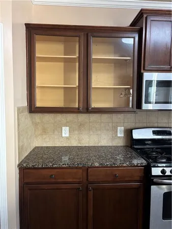 a kitchen with sink a microwave and cabinets