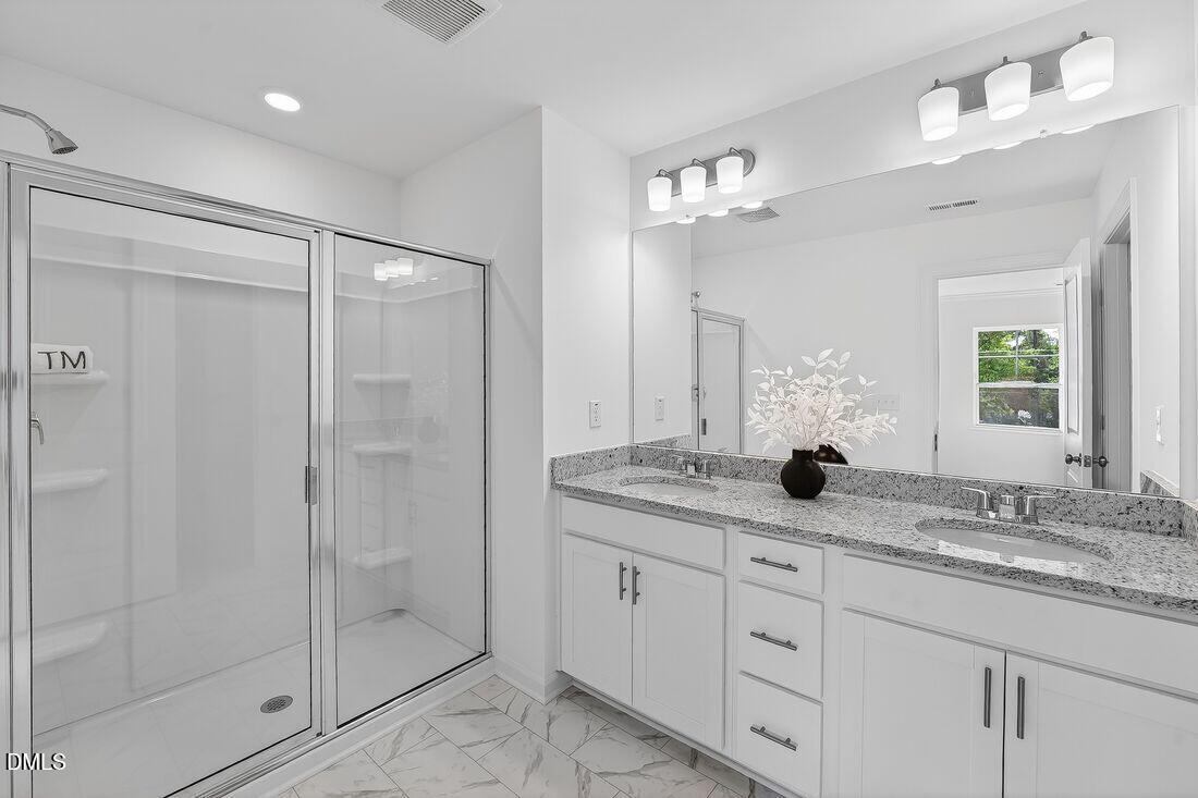 1324 West Garner Road, Unit 101 Garner, NC 27529 - Photo 22 of 29 a bathroom with a granite countertop sink a mirror and a shower