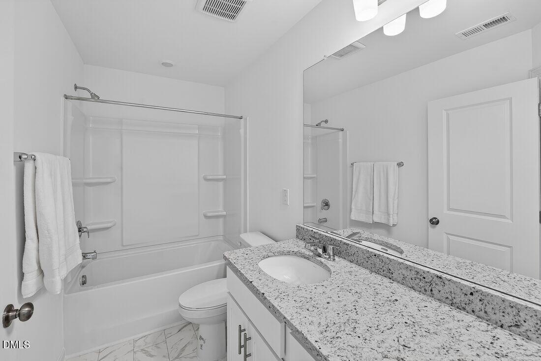 1324 West Garner Road, Unit 101 Garner, NC 27529 - Photo 27 of 29 a bathroom with a granite countertop sink a toilet a mirror and shower