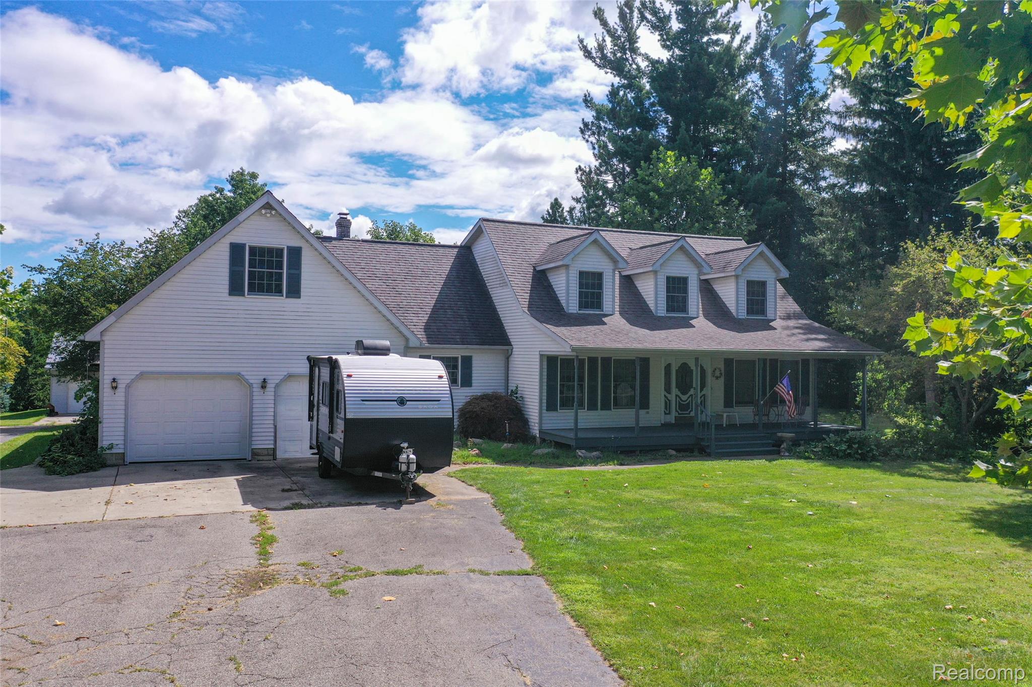 1591 Baldwin Road Lapeer, MI 48446 - Photo 33 of 46 Cape cod home with asphalt driveway, a front yard, a porch, a garage, and a shingled roof