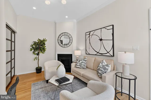 a living room with furniture a clock and a potted plant