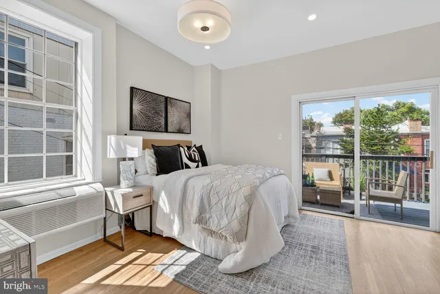 a bedroom with a bed and a large window
