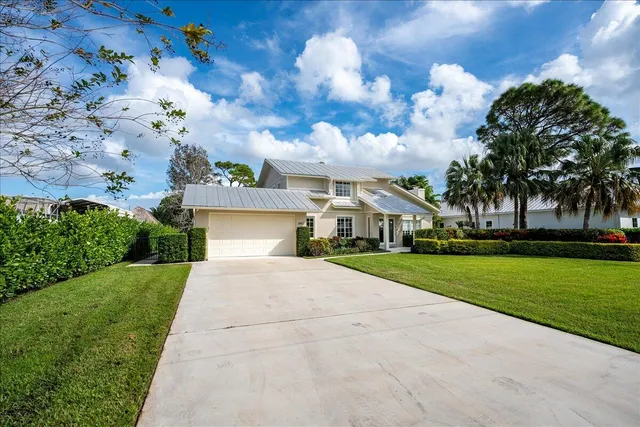 a view of a house with a big yard plants and large trees