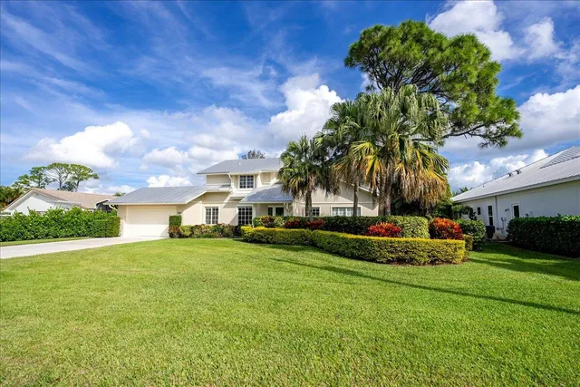 a front view of a house with a yard and trees