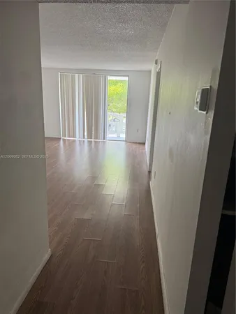 a view of hallway with wooden floor and window