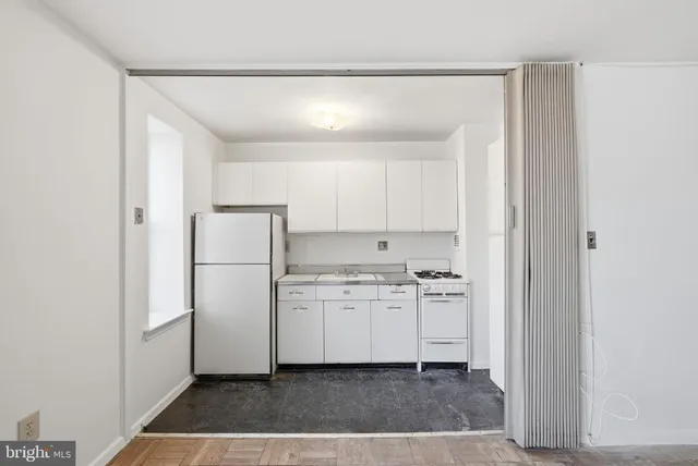 a kitchen with a refrigerator a stove and cabinets