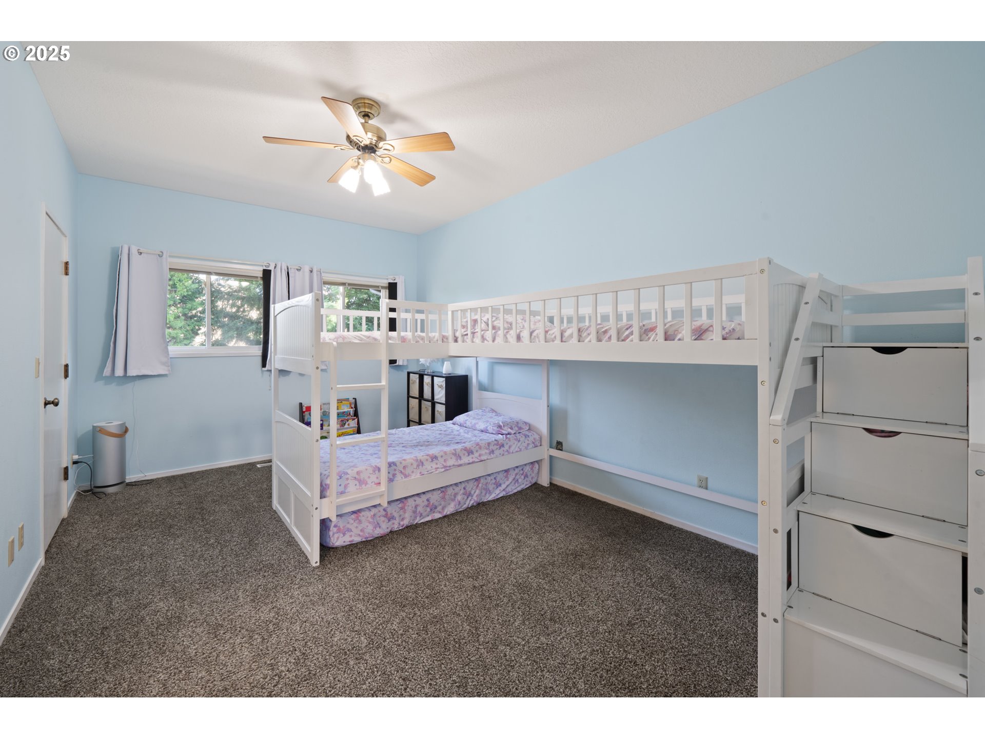 14330 Southeast Donatello Loop Happy Valley, OR 97086 - Photo 19 of 45 a spacious bedroom with a bed and a chandelier
