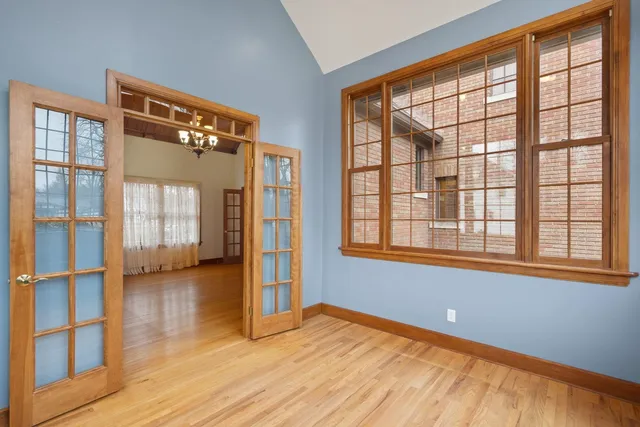 a view of a room with wooden floor chandelier and windows