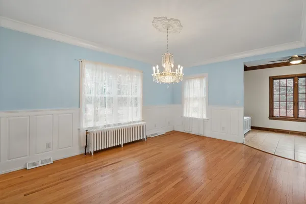 a view of a room with wooden floor chandelier and a window