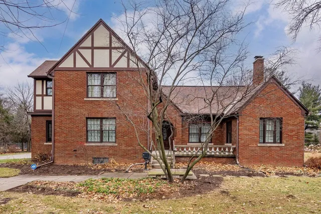 a view of a brick house with large windows and a gate