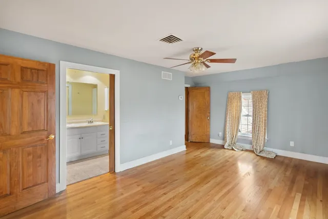 a bathroom with a granite countertop tub sink toilet window and mirror