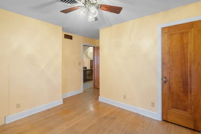 a view of a house with a big yard and large trees