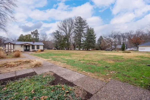 a white house that has a tree in front of it