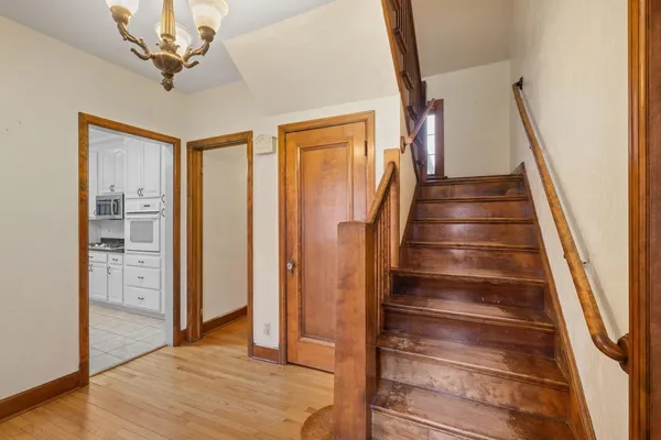 a view of a hallway with wooden floor and staircase