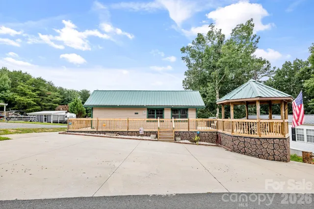 a patio with wooden floor a yard a table and chairs