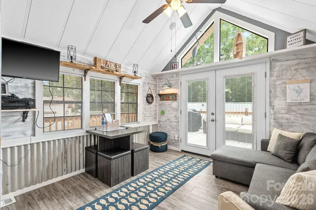 a living room with furniture a flat screen tv and large window
