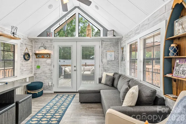 a living room with furniture a rug and a floor to ceiling window