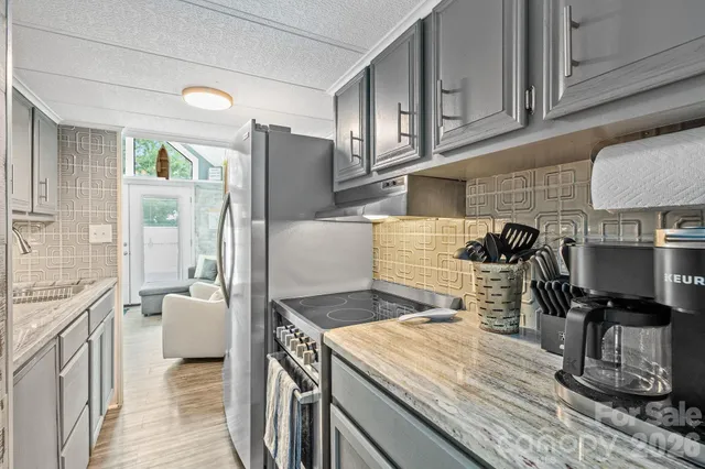 a kitchen with stainless steel appliances granite countertop a sink stove and refrigerator