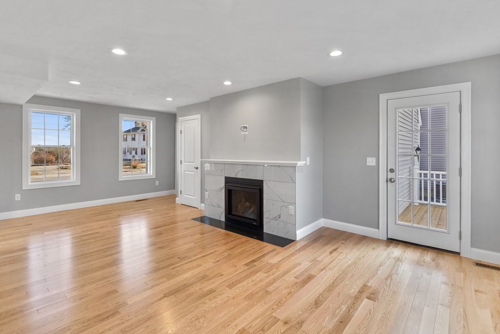 108 High Street Wareham, MA 02571 - Photo 18 of 40 a view of a livingroom with wooden floor and a fireplace