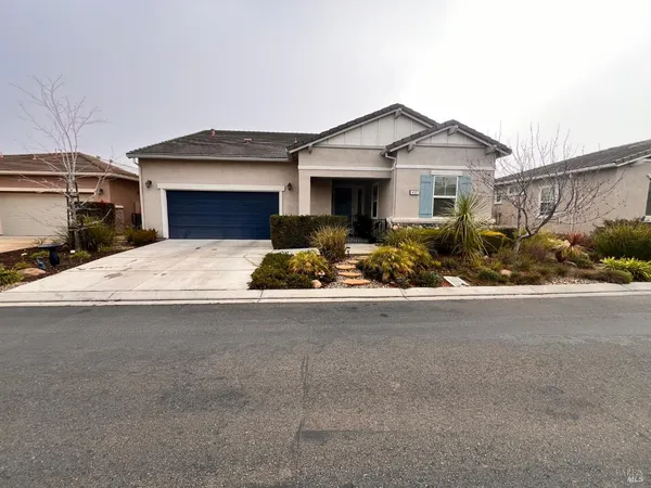 a front view of a house with yard outdoor seating and garage