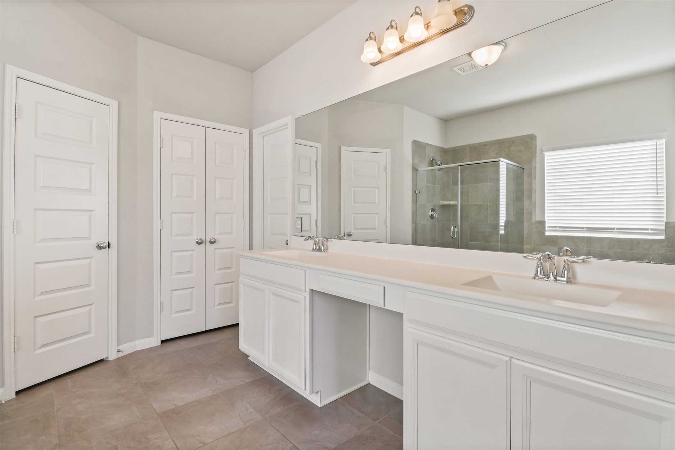 6010 Mapleton Meadow Lane Richmond, TX 77407 - Photo 21 of 34 a bathroom with a double vanity sink a mirror and a bathtub