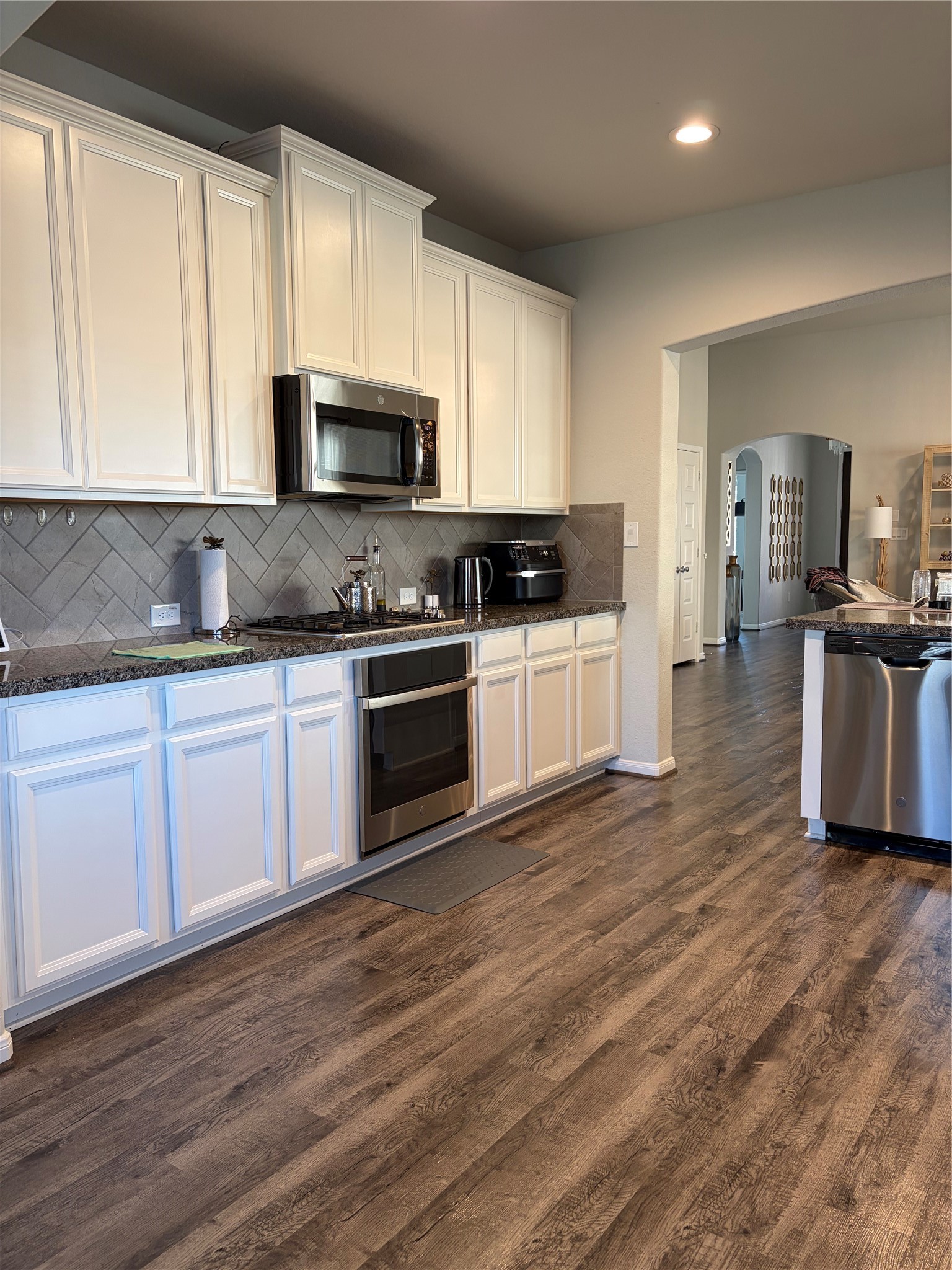 6010 Mapleton Meadow Lane Richmond, TX 77407 - Photo 28 of 34 a kitchen with stainless steel appliances granite countertop a stove a sink and a microwave