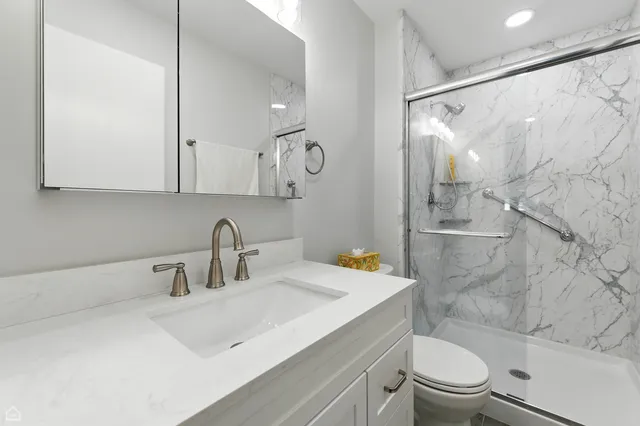 a bathroom with a sink a toilet and shower