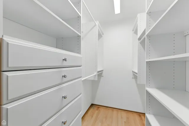 a view of walk in closet with empty racks
