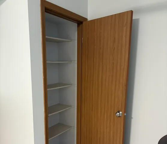 a view of walk in closet with empty racks