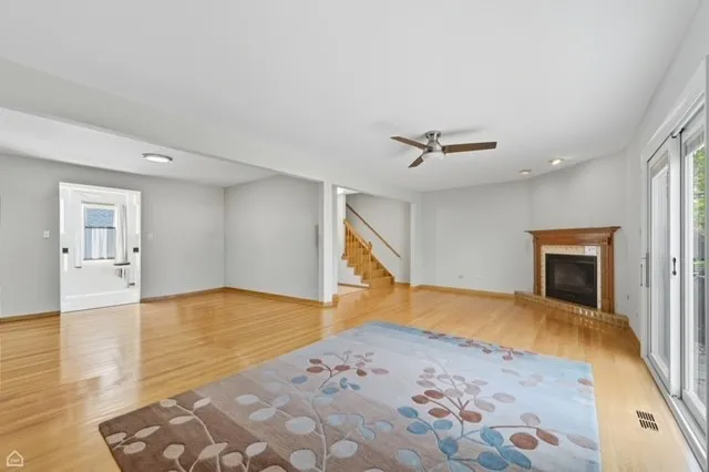 a view of a livingroom with wooden floor and a ceiling fan