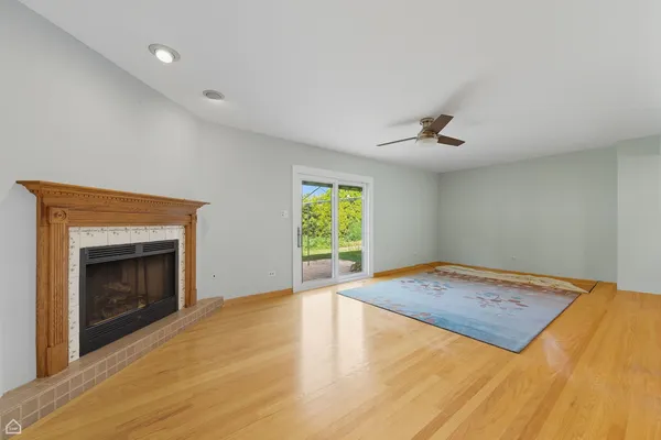 a view of empty room with wooden floor and fireplace