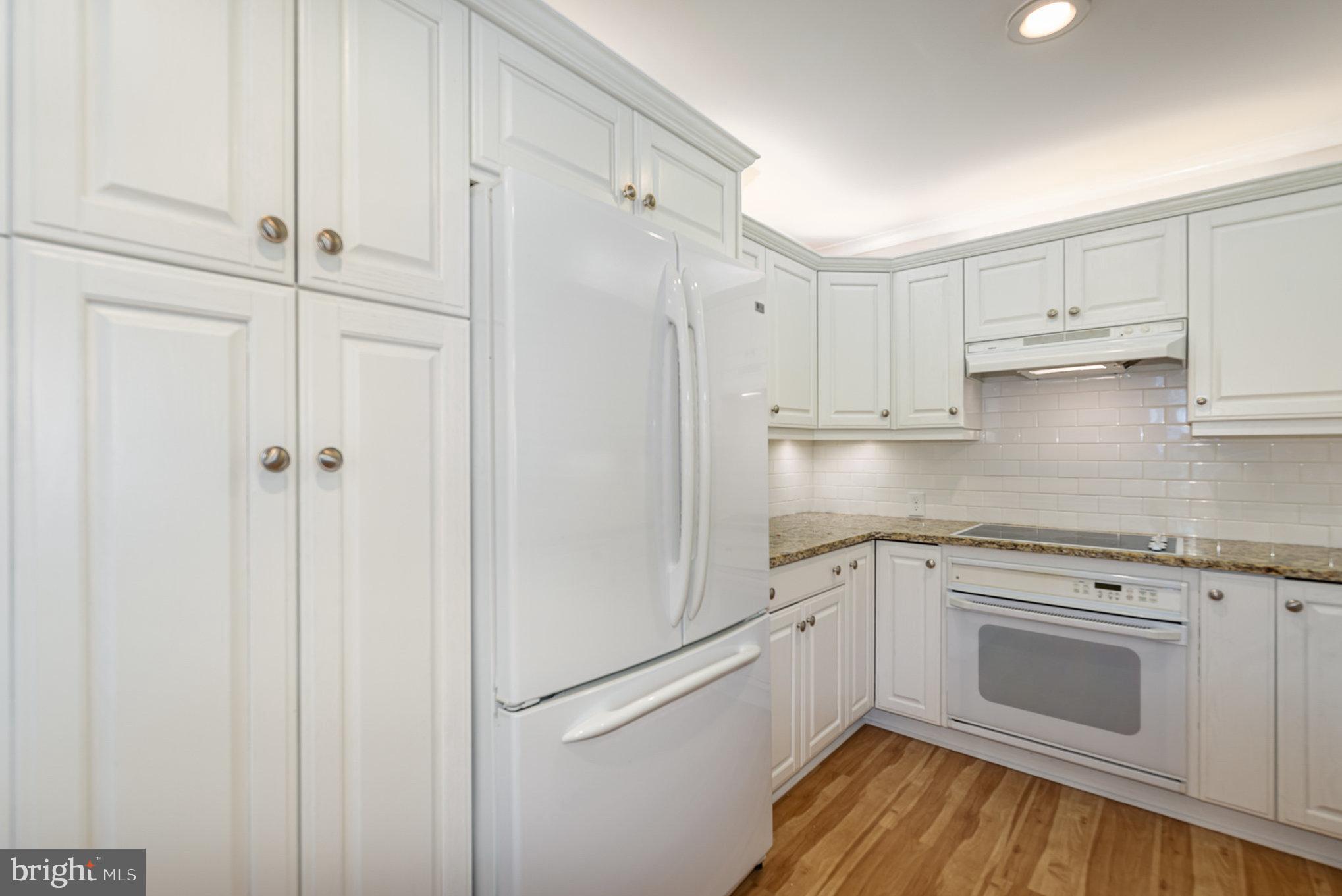 939 Starbit Road Towson, MD 21286 - Photo 11 of 52 a kitchen with white cabinets and white appliances