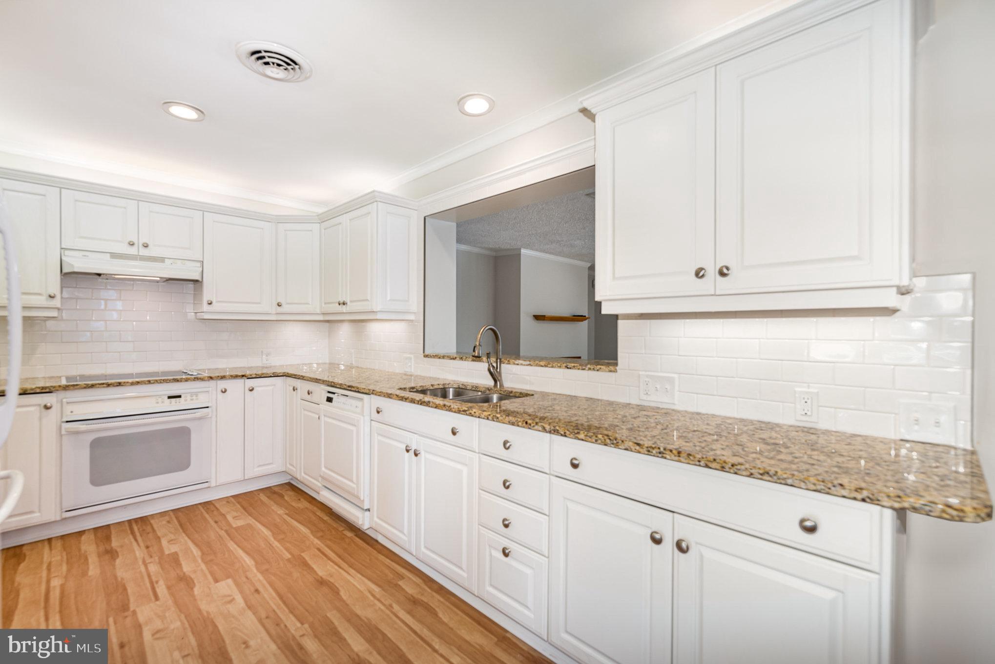939 Starbit Road Towson, MD 21286 - Photo 12 of 52 a kitchen with granite countertop cabinets stainless steel appliances a sink and wooden floor