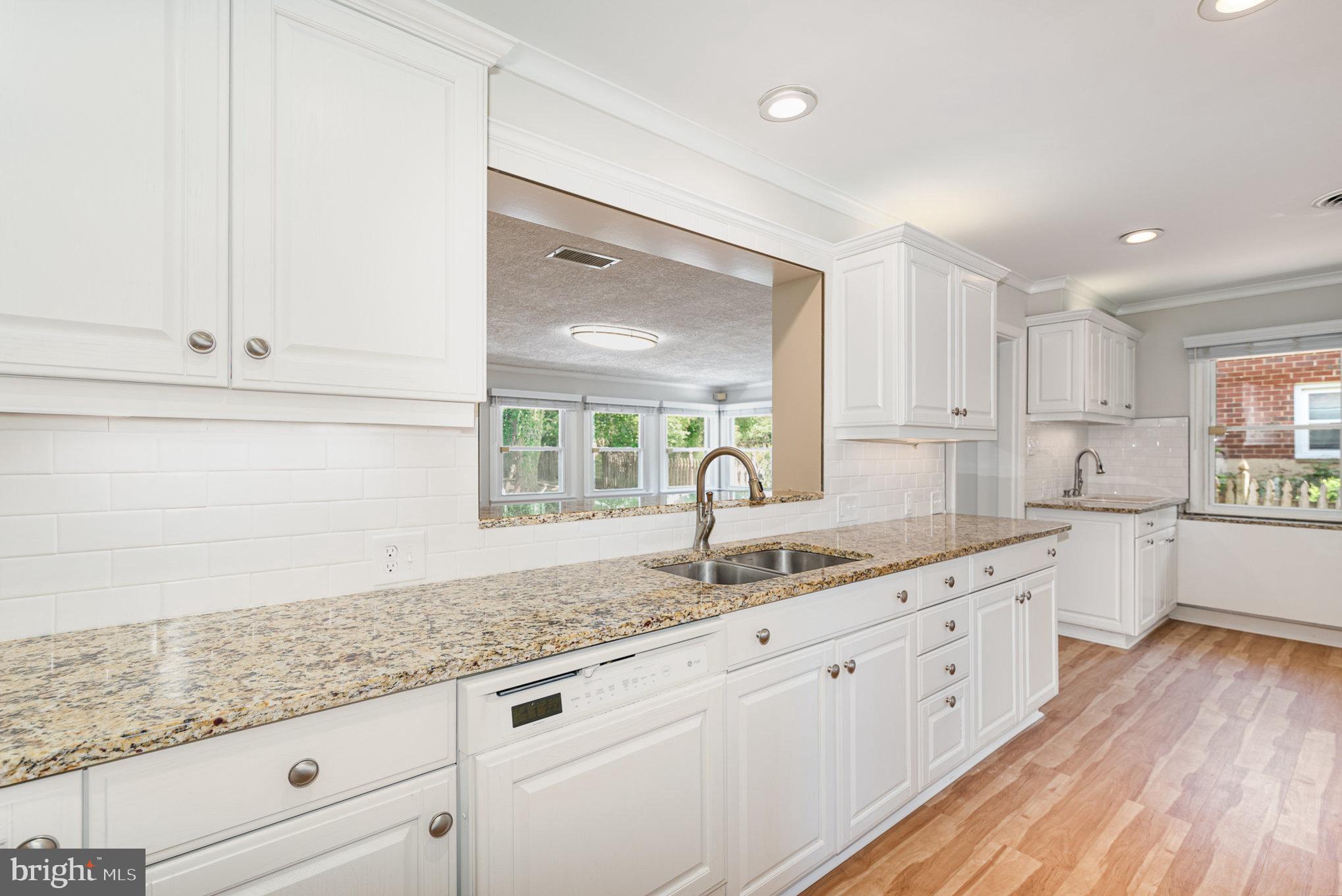 939 Starbit Road Towson, MD 21286 - Photo 9 of 52 a kitchen with granite countertop white cabinets and white appliances