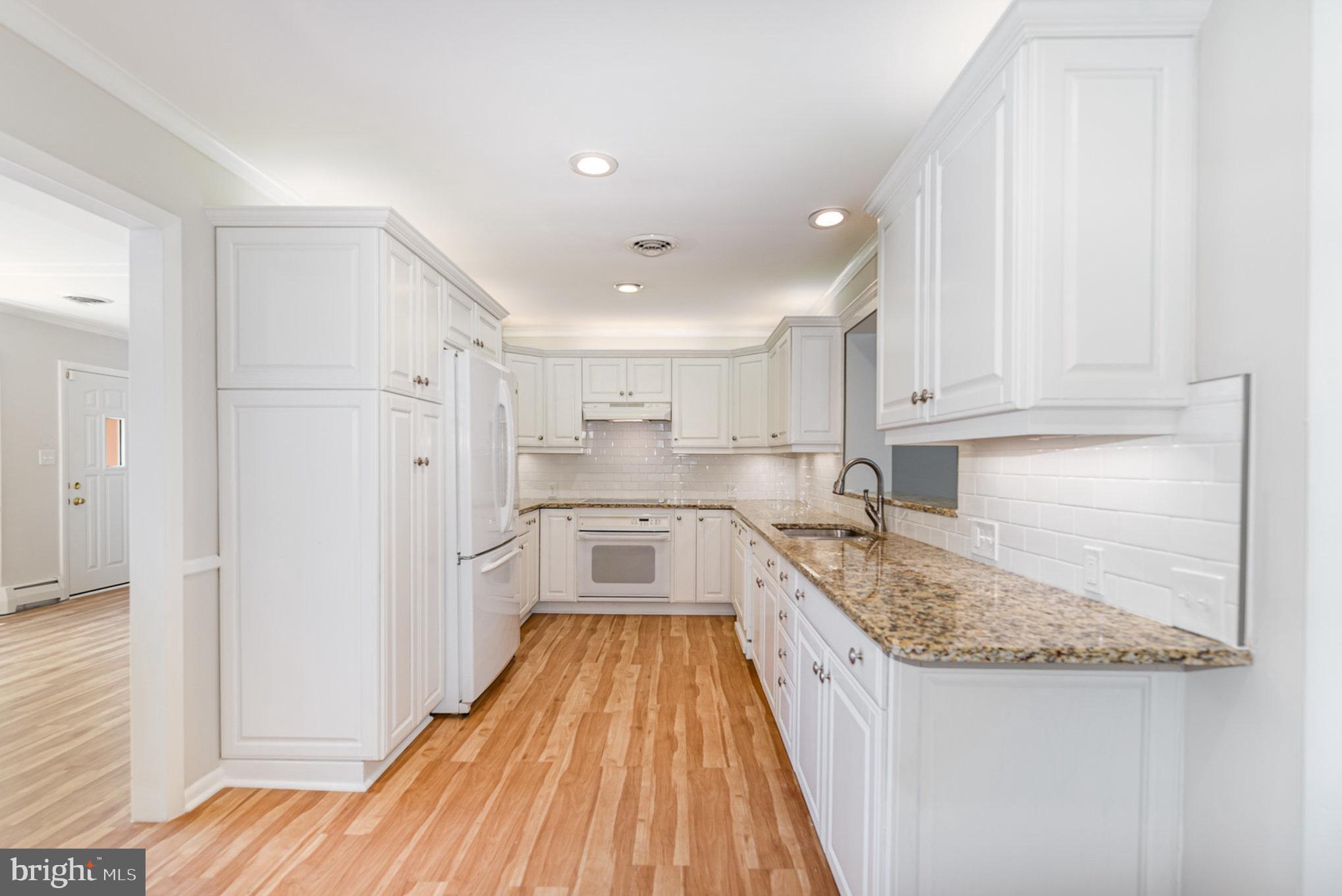 939 Starbit Road Towson, MD 21286 - Photo 10 of 52 a kitchen with granite countertop kitchen island wooden cabinets stainless steel appliances and a counter space